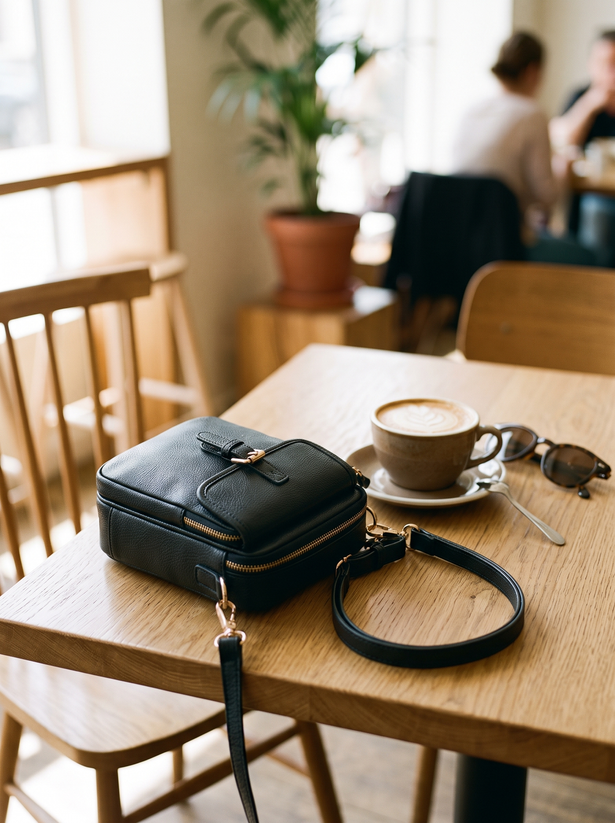 De Ruimste Crossbodytas, grijs, op tafel